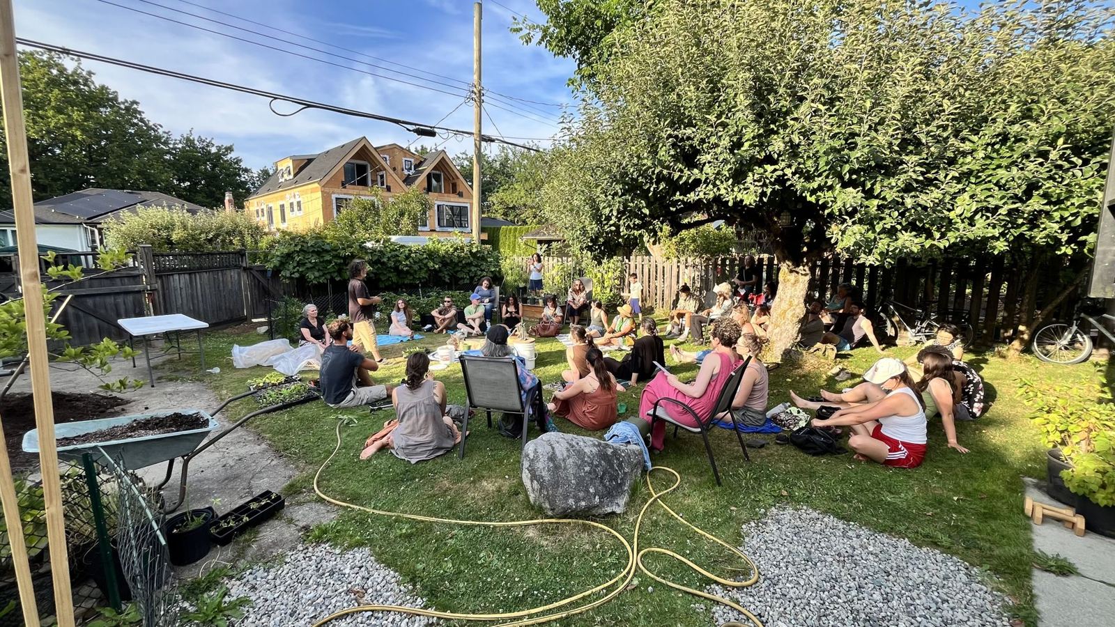 A crowd gathered in a backyard for a community growing workshop