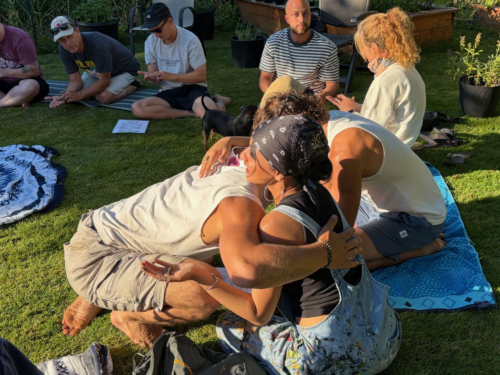 Two workshop participants sharing a warm embrace on the lawn